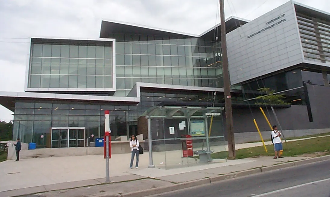 Glass and metal front of Centennial's Science and Technology Centre at Morningside, with a bus shelter on Morningside Avenue