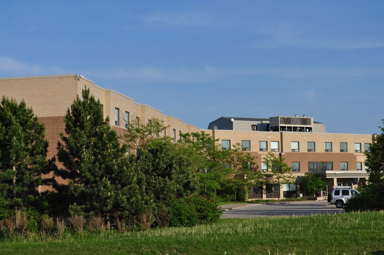 Low-rise brick residence building at Seneca King Campus behind evergreen trees