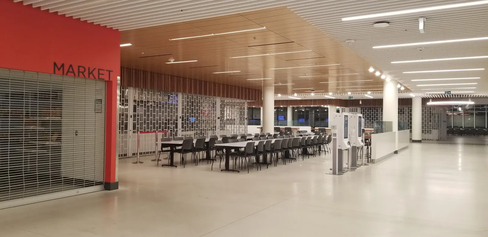 Long rows of tables in The Pond cafeteria at Seneca Newnham Campus, beside a market counter
