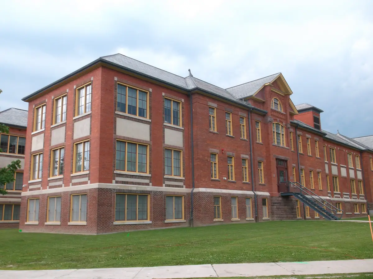 Red-brick Building H at Humber Lakeshore Campus, a former hospital cottage with tall yellow-framed windows