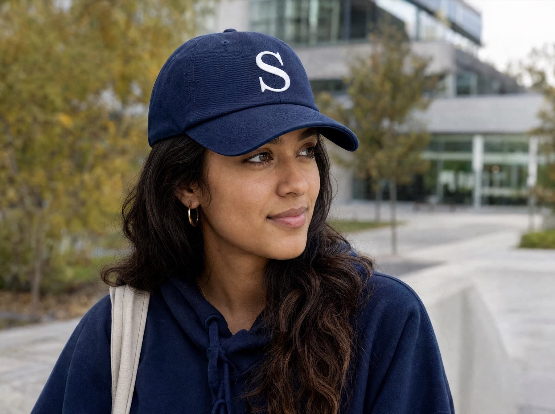 Student wearing the navy Campus Run Cap outside a university library