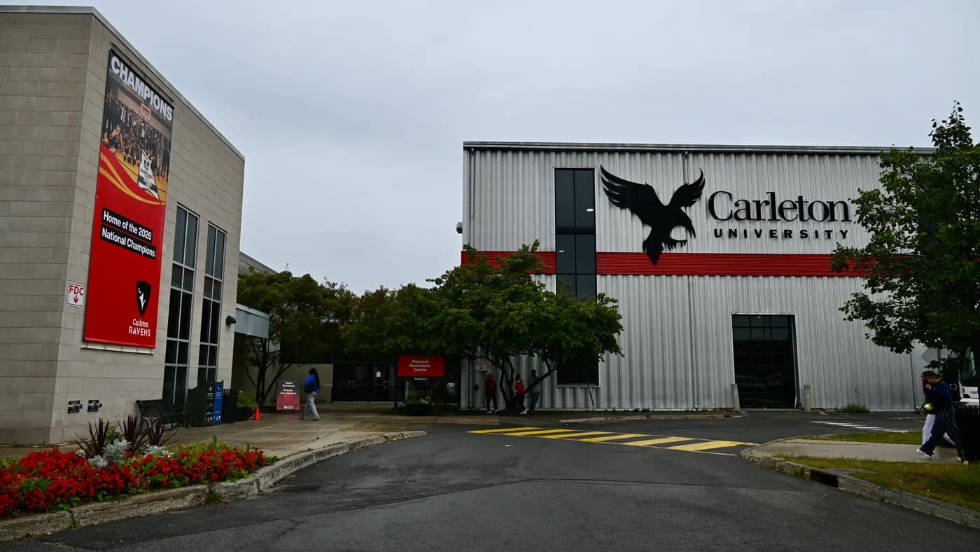 Carleton athletics buildings with a Ravens 'Home of the 2026 National Champions' banner, a Physical Recreation Centre sign and a metal-clad building with a raven logo and the Carleton University wordmark