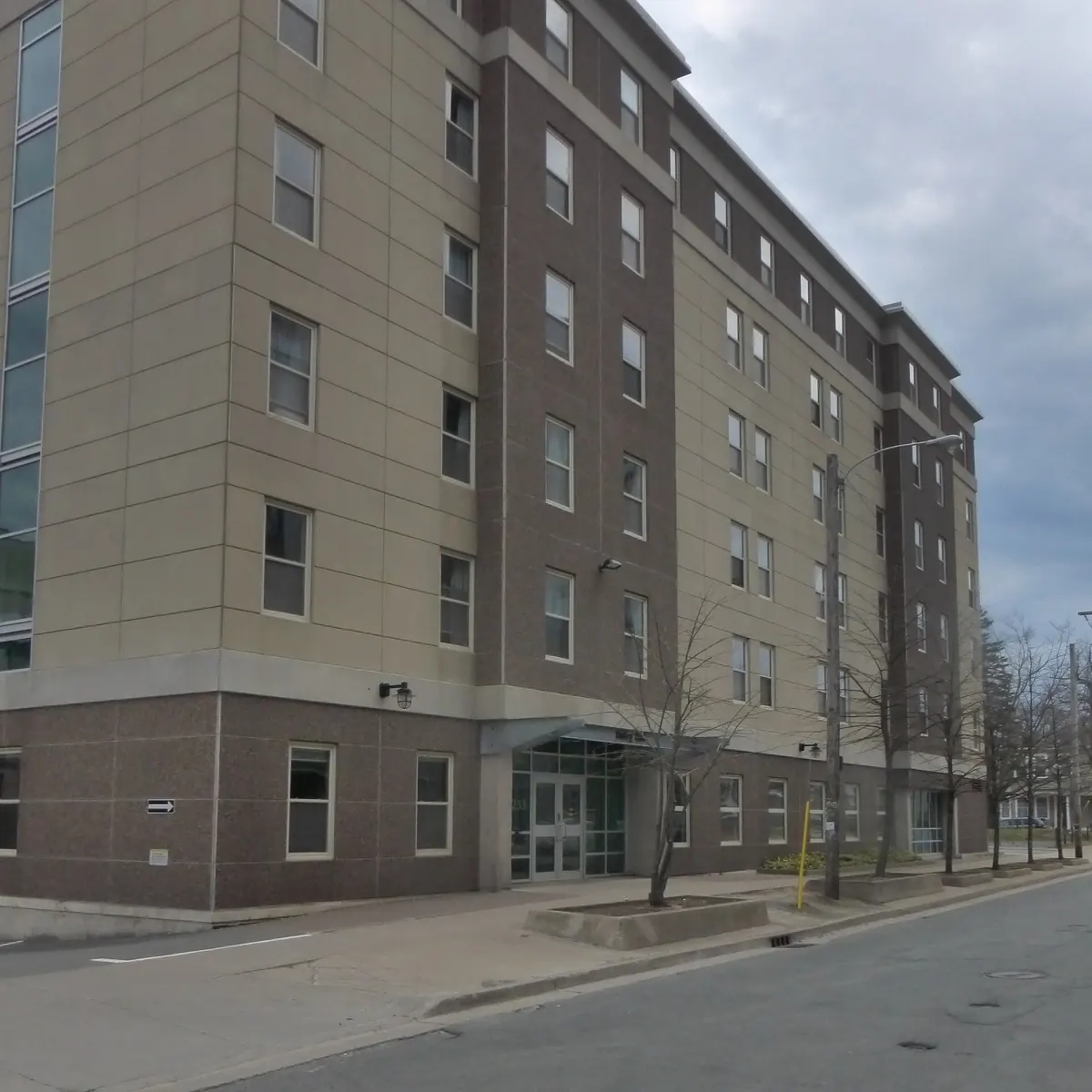 Six-storey Risley Hall at Dalhousie, with beige and brown brick walls, rows of windows and a glass entrance on a street corner