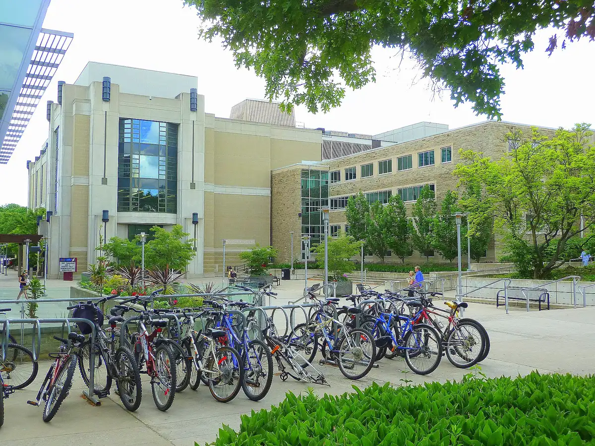 Mills Memorial Library's stone and glass entrance behind a plaza with parked bicycles at McMaster