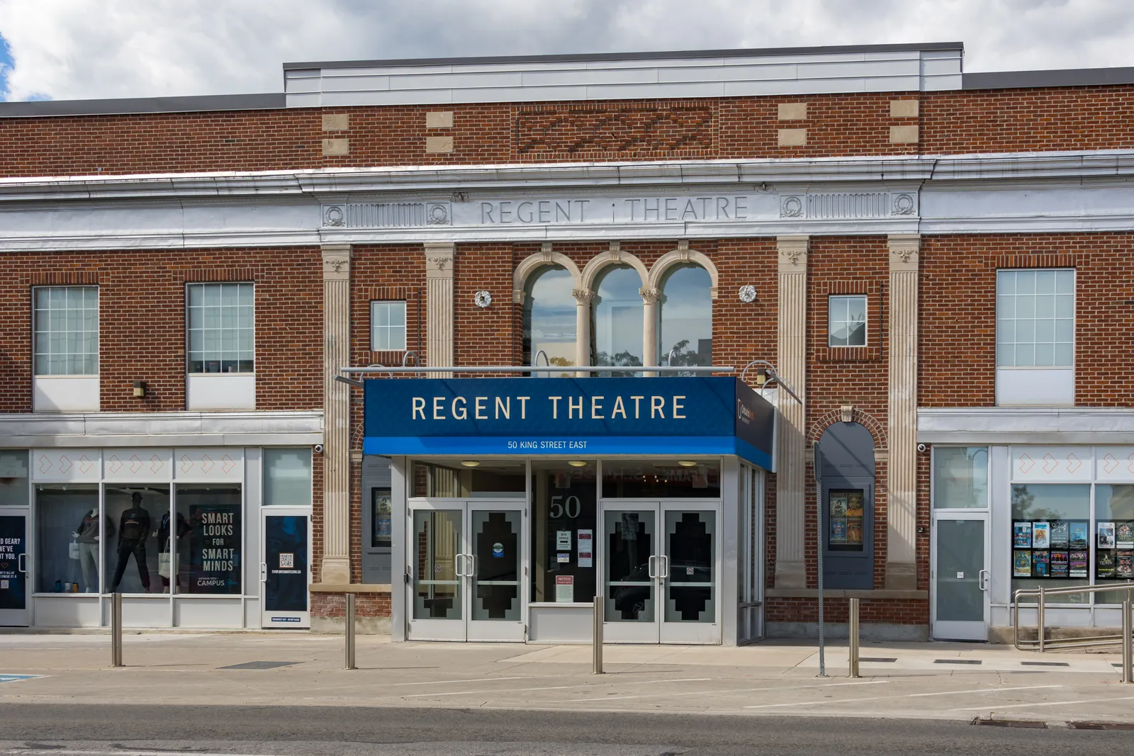 Brick facade of the Regent Theatre at 50 King Street East in downtown Oshawa, with a blue Regent Theatre canopy over glass doors