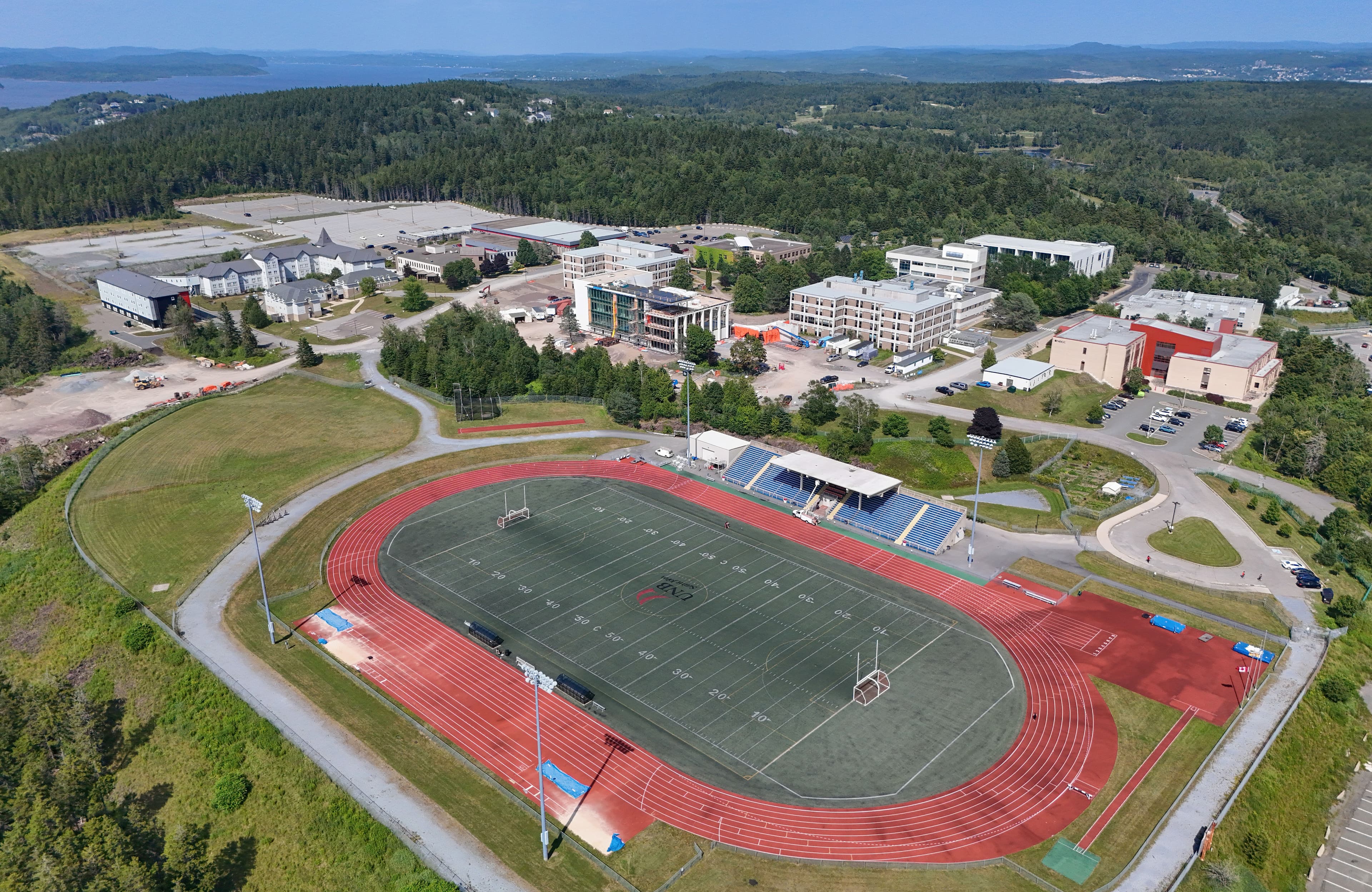 Aerial view of UNB’s Saint John campus with a track, playing field and academic buildings