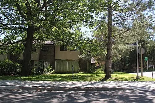 A low-rise Schreiberwood residence building behind trees at U of T Mississauga