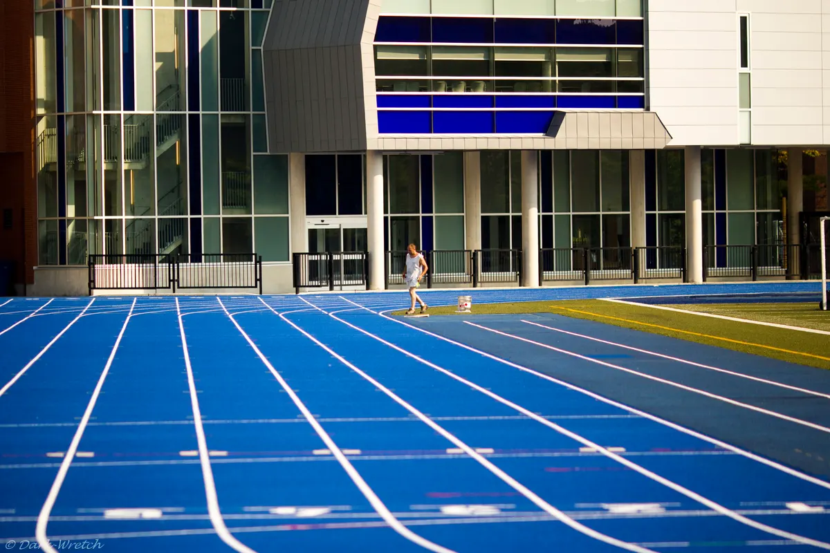 Blue outdoor running lanes beside the field at U of T's Varsity Stadium