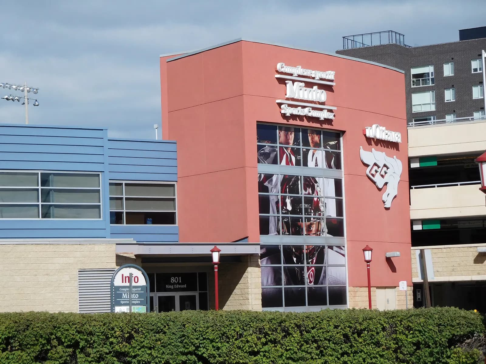 Red entrance tower of the uOttawa Minto Sports Complex at 801 King Edward, with Minto Sports Complex lettering, Gee-Gees logo and hockey player banners