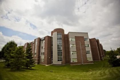 Brick residence wings and a glazed stairwell at Waterloo's Mackenzie King Village