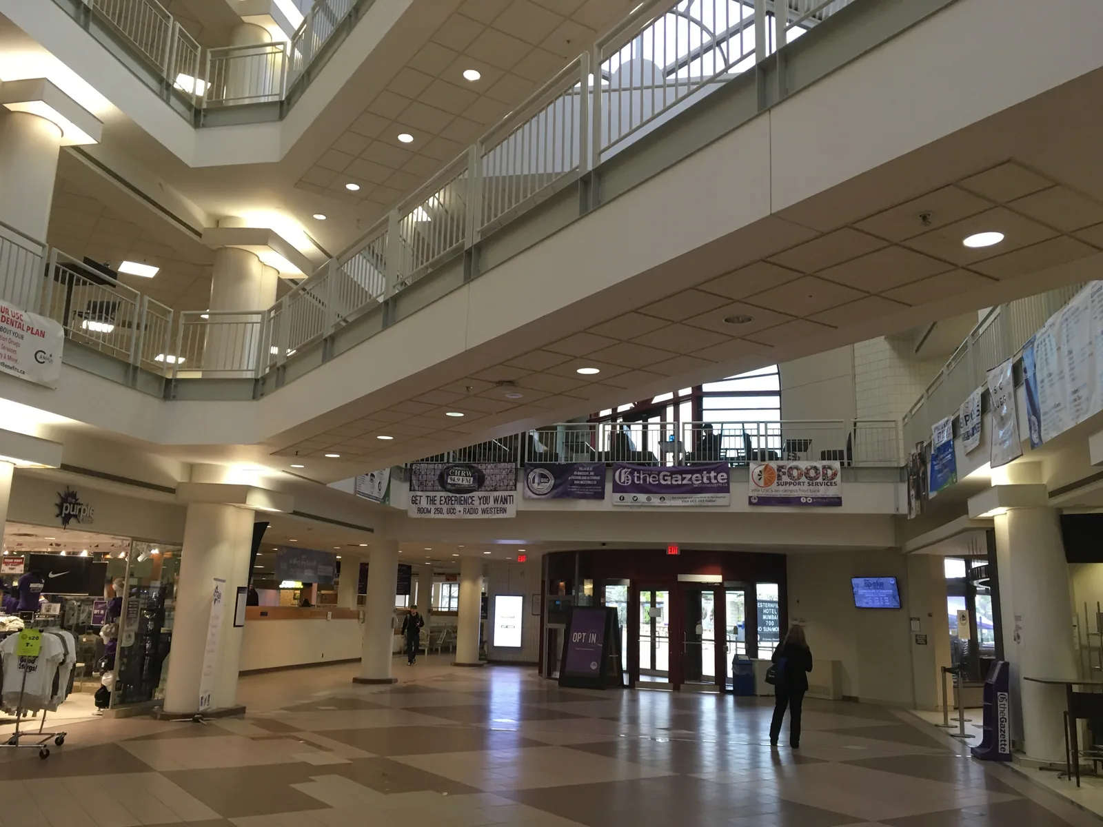 Multi-level atrium of Western's University Community Centre with white balconies, a store and entrance doors