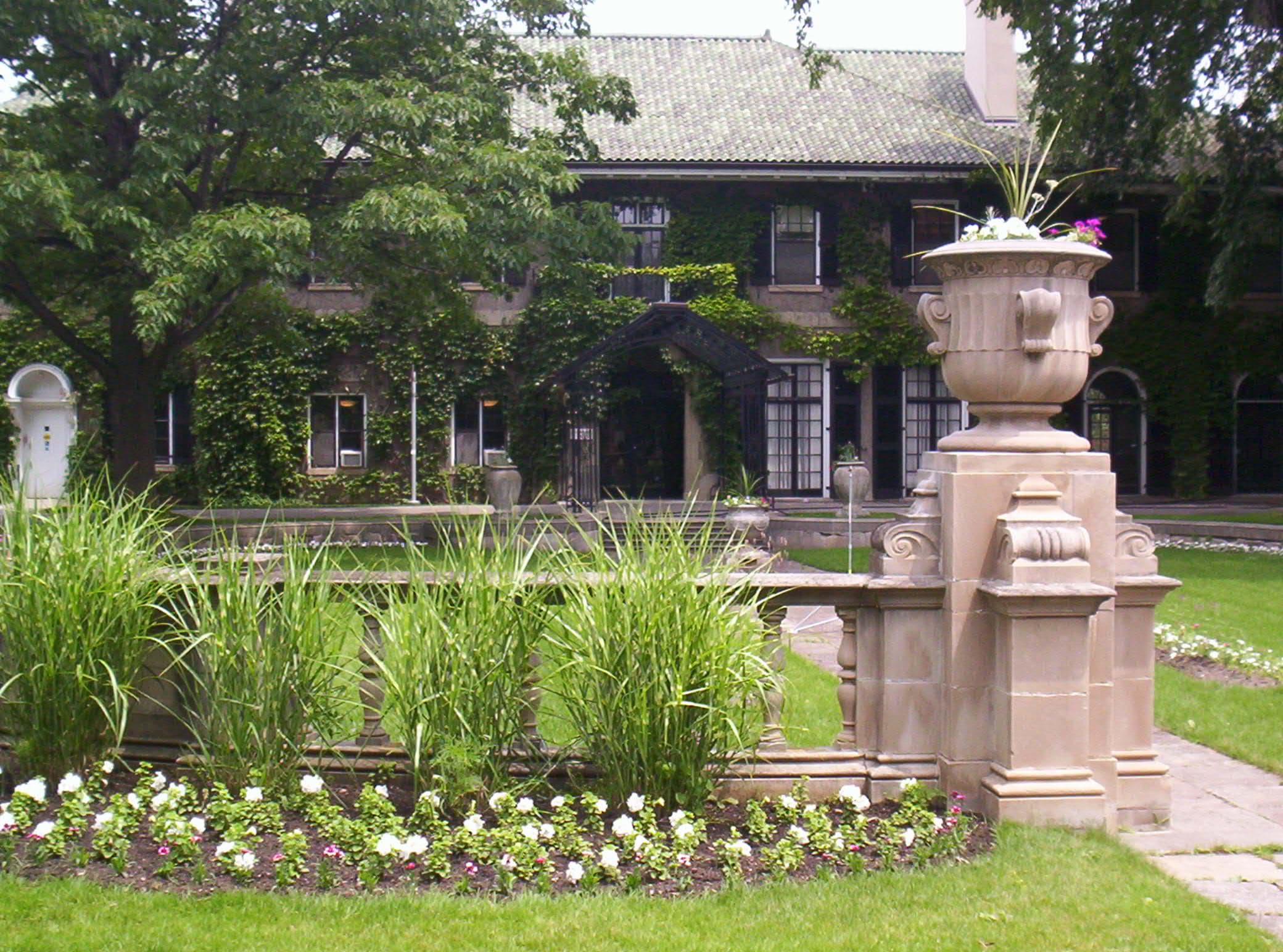 Glendon manor behind an ornamental garden and stone urn at York University